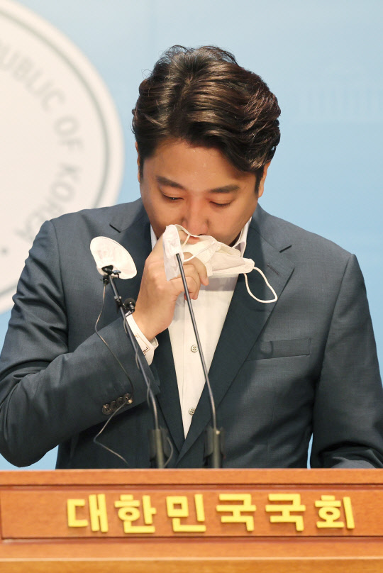 '성접대 증거인멸교사 의혹'으로 당원권 6개월 정지 당내 징계를 받은 상태에서 비상대책위원회 출범으로 자동해임된 이준석 국민의힘 전 대표가 13일 오후 국회 소통관에서 기자회견을 열고 당 비대위 체제 전환에 대한 효력정지 가처분 신청 등과 관련해 직접 입장을 밝히던 중 마스크로 눈물을 닦는 모습을 보이고 있다<국회사진기자단·연합뉴스>